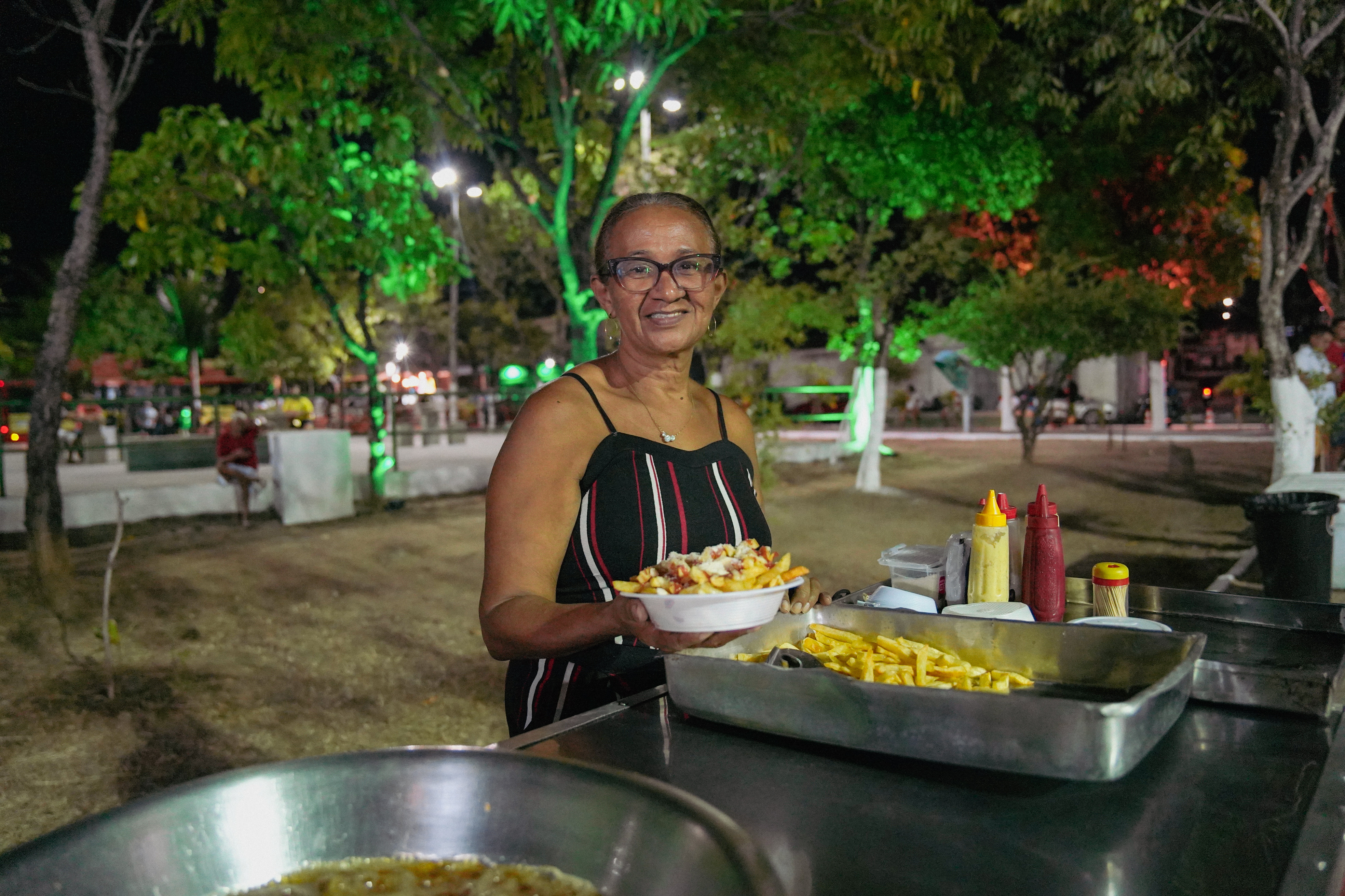 Lurdes Almada segura um pratinho de batata frita